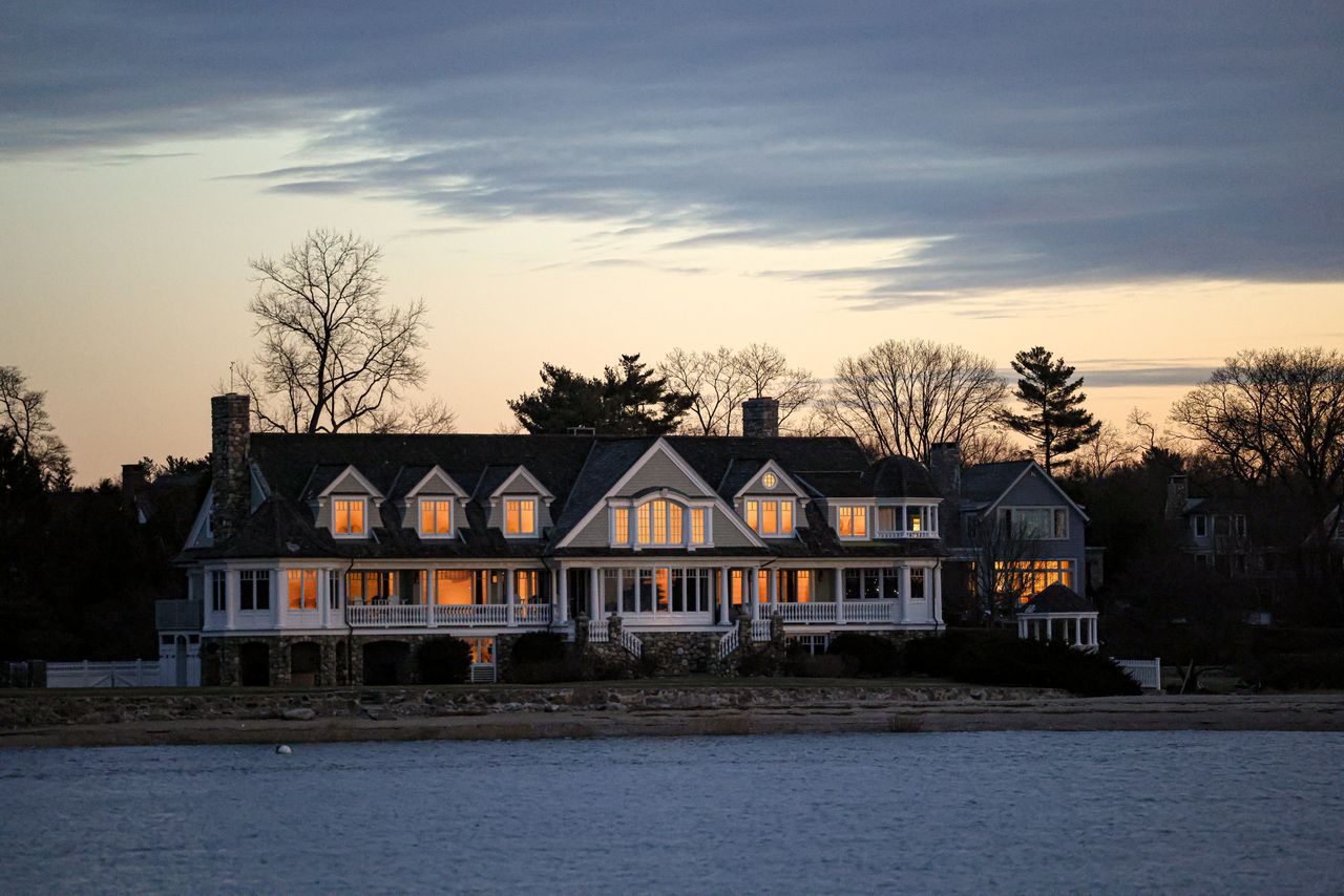 Mastering the First Impression: Your intriguing post title goes here Elegant waterfront home in Stamford, Connecticut, captured at twilight with glowing windows and serene surroundings.