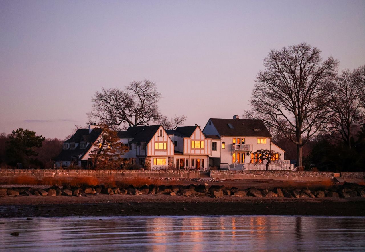 The Art of Drawing Readers In: Your attractive post title goes here Scenic view of rural houses by lakeshore with sunset reflecting on windows, creating a warm ambiance.